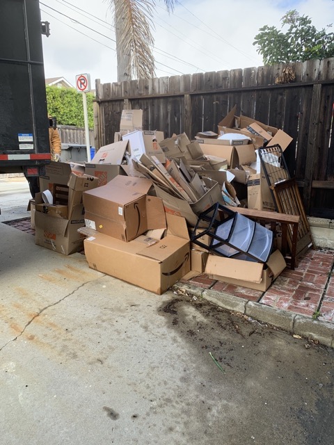 Cardboard and broken furniture beside the junk removal truck