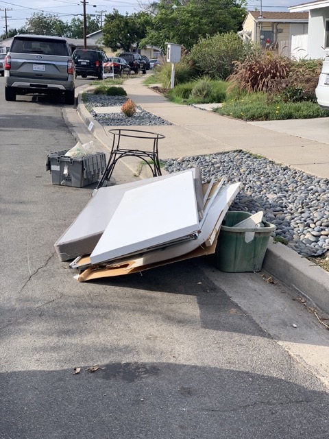 Broken furniture and panels at a San Diego curb