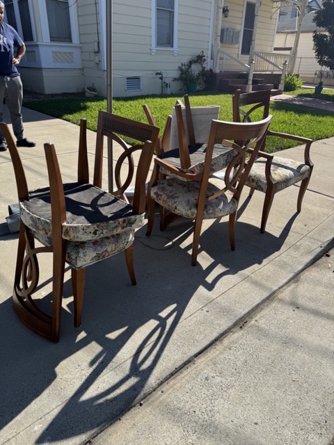 Dining chairs set on a sidewalk for furniture removal