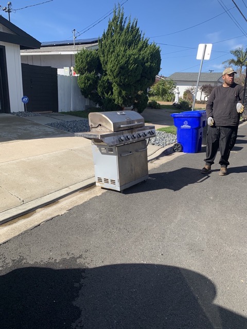 Gas grill staged at the curb for junk removal