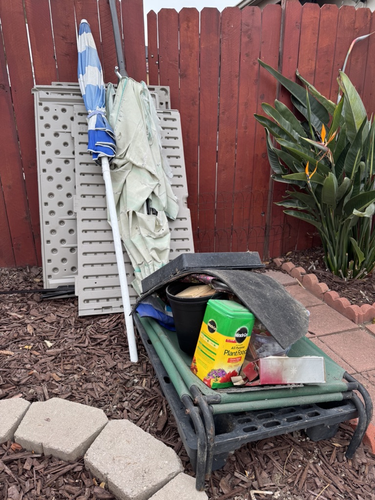 Lounge chair, umbrella, and yard items set out for pickup