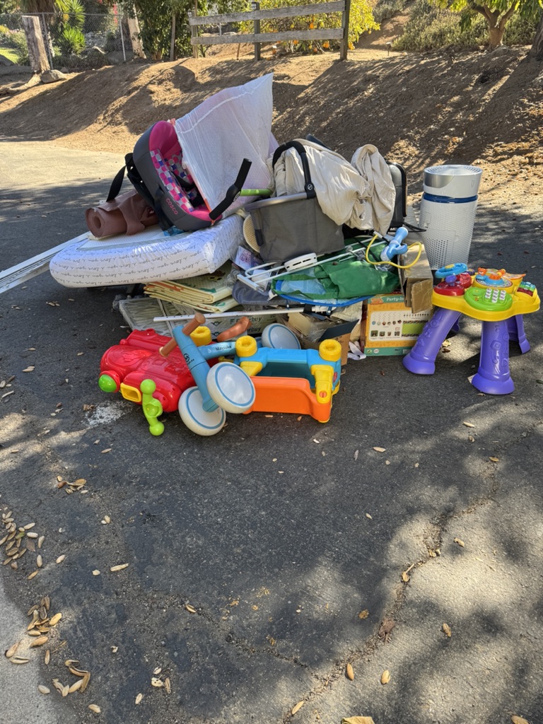 Toys, a crib mattress, and household junk piled for pickup
