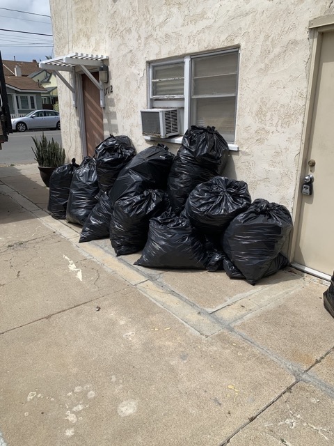 Black trash bags stacked for junk removal