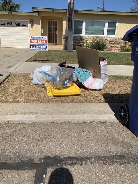 Mixed junk piled on a front yard for same day removal